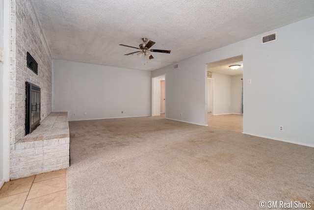 3317 Rockbrook Dr, San Angelo, TX 76904 - unfurnished living room with ceiling fan, a brick fireplace, light colored carpet, and a textured ceiling