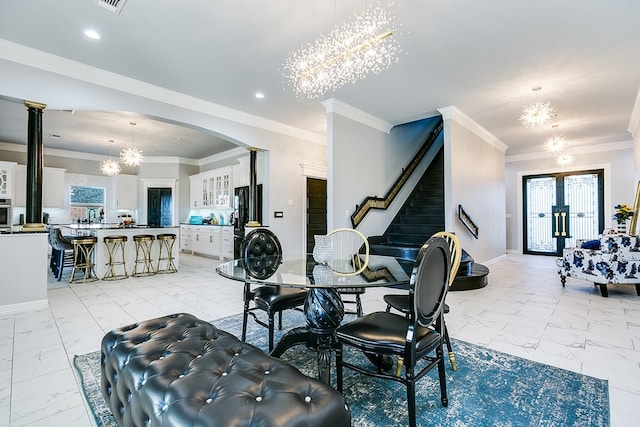 dining area with crown molding, a healthy amount of sunlight, sink, and a chandelier