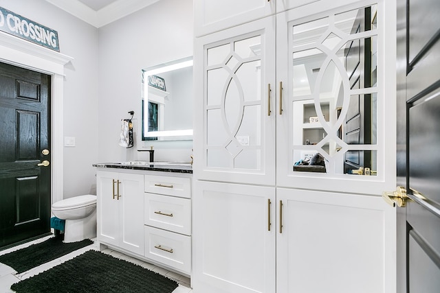 bathroom featuring crown molding, vanity, toilet, and tile patterned flooring