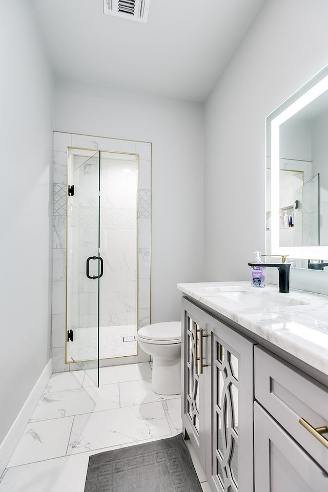 bathroom with vanity, a shower with shower door, and toilet