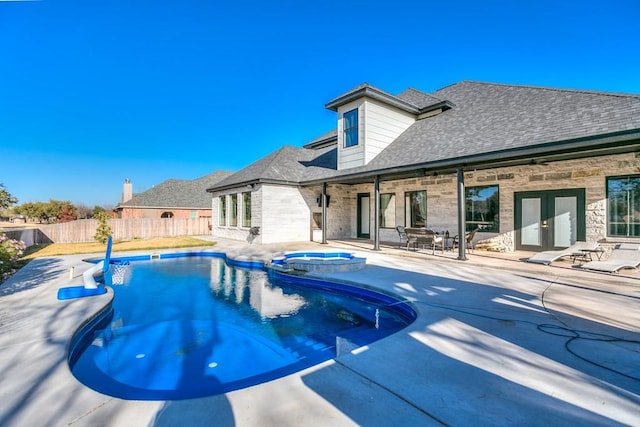 view of swimming pool with french doors and a patio