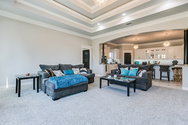 living room with an inviting chandelier, crown molding, light carpet, and a raised ceiling