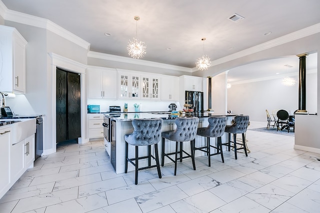 kitchen with white cabinetry, hanging light fixtures, a kitchen island, a notable chandelier, and a kitchen bar