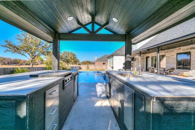 view of swimming pool with area for grilling, sink, and a patio