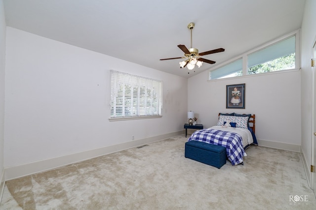 bedroom with multiple windows, light carpet, vaulted ceiling, and ceiling fan