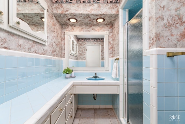 bathroom with tile patterned flooring, vanity, and walk in shower