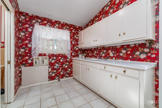 kitchen featuring white cabinetry, sink, and light tile patterned floors