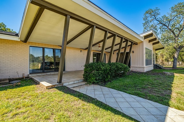 property entrance featuring a yard and a patio