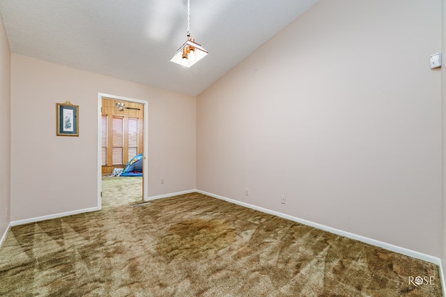 carpeted empty room featuring lofted ceiling