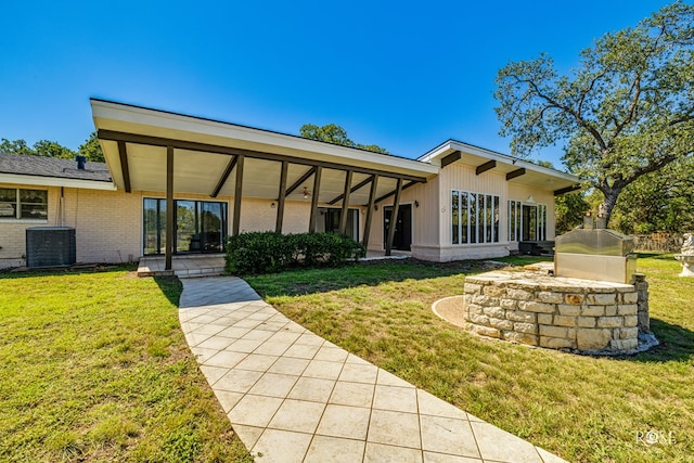 rear view of house featuring a yard and cooling unit