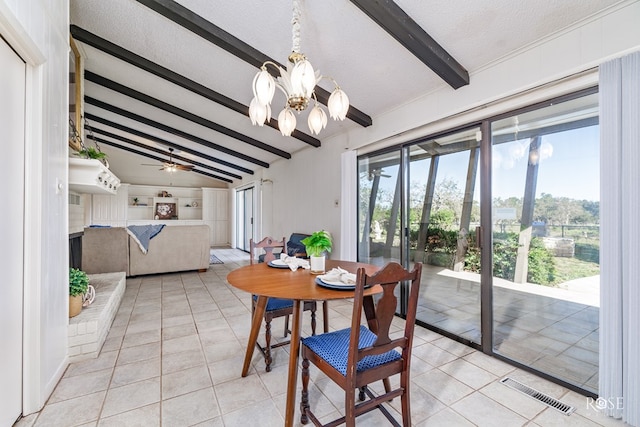 dining space featuring ceiling fan with notable chandelier, lofted ceiling with beams, a textured ceiling, and light tile patterned floors