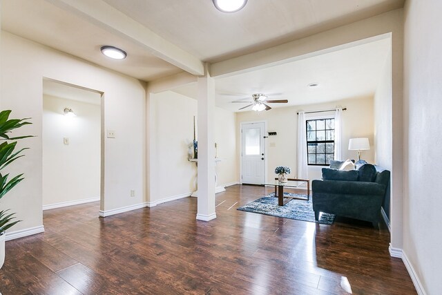 entrance foyer with decorative columns, ceiling fan, dark wood-type flooring, and beam ceiling