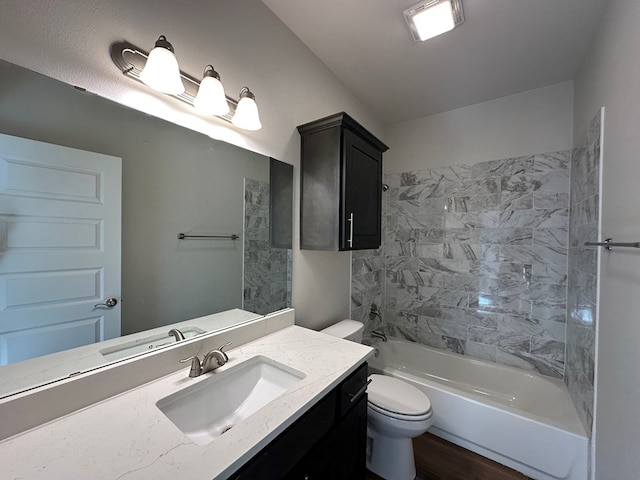 full bathroom with tiled shower / bath, vanity, and toilet