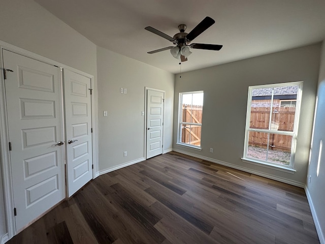 unfurnished bedroom featuring ceiling fan and dark hardwood / wood-style flooring