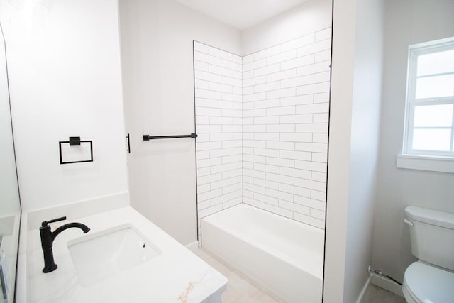 full bathroom featuring tiled shower / bath combo, vanity, and toilet