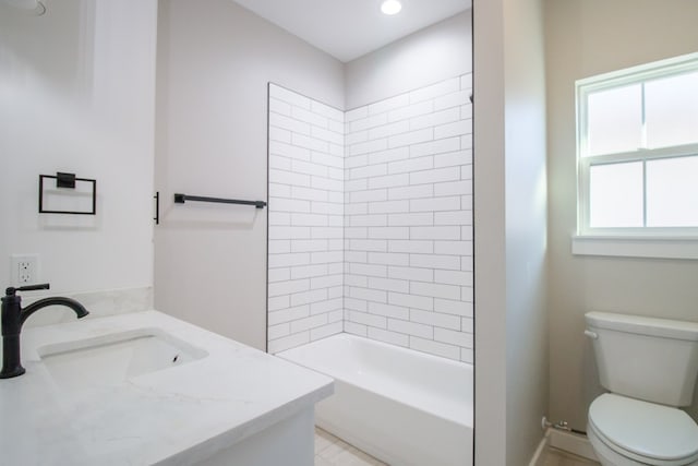 full bathroom with vanity, tiled shower / bath combo, and toilet