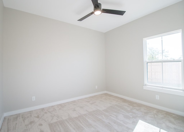 carpeted spare room featuring a wealth of natural light and ceiling fan