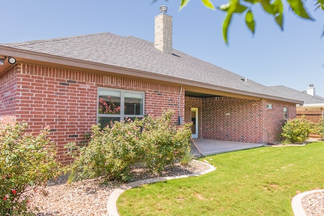 1906 Colonial Dr, San Angelo, TX 76904 - back of property featuring a chimney, brick siding, roof with shingles, and a patio