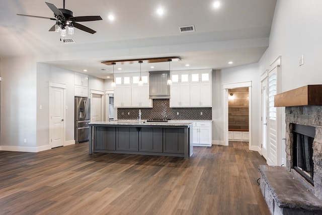 1906 Colonial Dr, San Angelo, TX 76904 - kitchen with white cabinetry, a stone fireplace, backsplash, dark wood finished floors, and recessed lighting