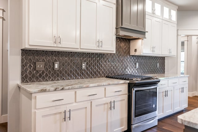 1906 Colonial Dr, San Angelo, TX 76904 - kitchen with stainless steel gas range oven, backsplash, white cabinetry, dark wood-style flooring, and light stone countertops