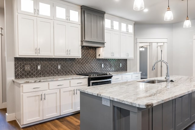 1906 Colonial Dr, San Angelo, TX 76904 - kitchen featuring dark wood-type flooring, stainless steel gas range oven, custom range hood, white cabinetry, and light stone countertops