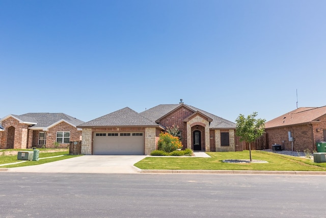 1906 Colonial Dr, San Angelo, TX 76904 - ranch-style house with brick siding, roof with shingles, a garage, a front lawn, and driveway