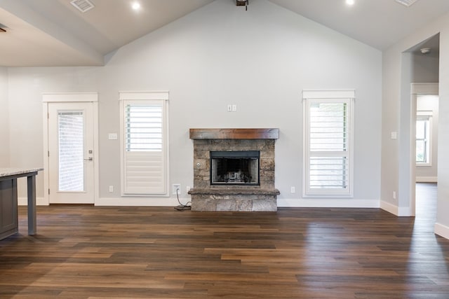 1906 Colonial Dr, San Angelo, TX 76904 - unfurnished living room featuring a stone fireplace, high vaulted ceiling, dark wood-type flooring, healthy amount of natural light, and recessed lighting