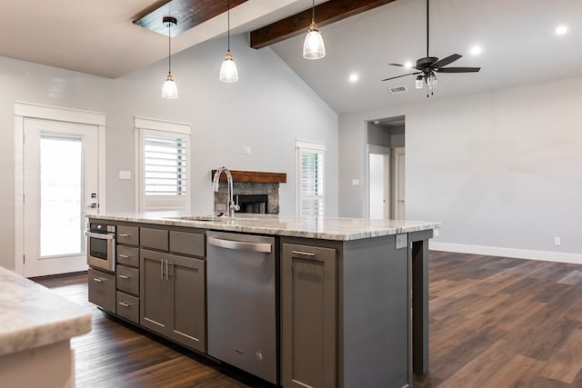 1906 Colonial Dr, San Angelo, TX 76904 - kitchen with a stone fireplace, appliances with stainless steel finishes, open floor plan, beamed ceiling, and ceiling fan