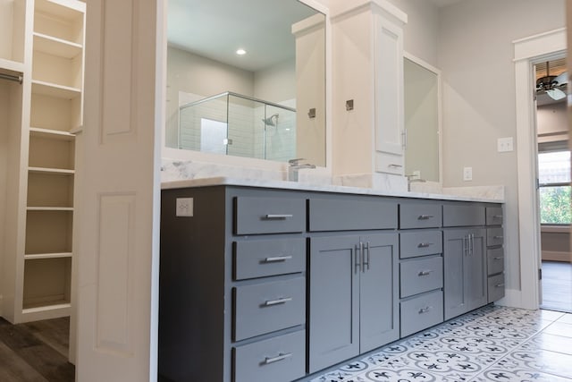 1906 Colonial Dr, San Angelo, TX 76904 - full bath featuring a shower stall, double vanity, tile patterned floors, a walk in closet, and a ceiling fan