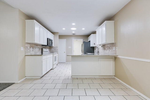 kitchen featuring backsplash, stainless steel appliances, recessed lighting, and white cabinetry