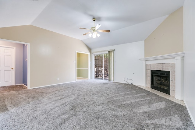 unfurnished living room with carpet floors, lofted ceiling, baseboards, a tiled fireplace, and a ceiling fan