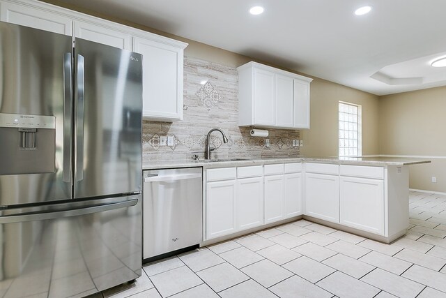 kitchen featuring stainless steel fridge, light countertops, tasteful backsplash, a sink, and dishwasher