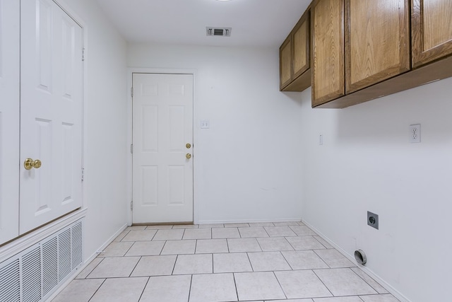 clothes washing area featuring cabinet space, electric dryer hookup, visible vents, and baseboards