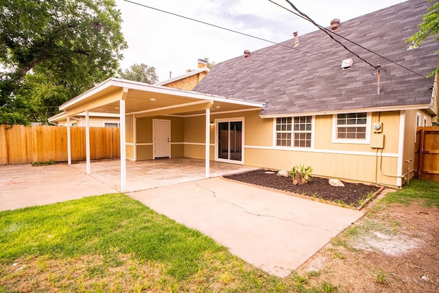 1521 S Jackson St, San Angelo, TX 76904 - back of property featuring a shingled roof, a chimney, and an attached carport