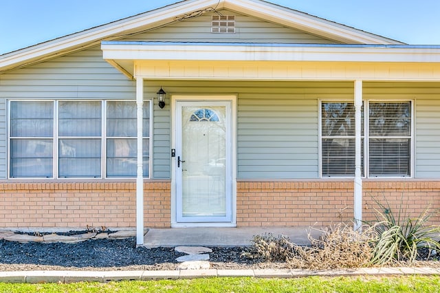 property entrance featuring brick siding