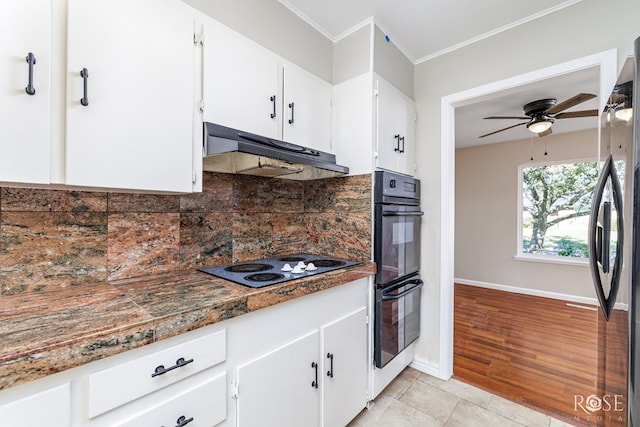 kitchen featuring stainless steel fridge, black double oven, electric stovetop, white cabinets, and light tile patterned flooring