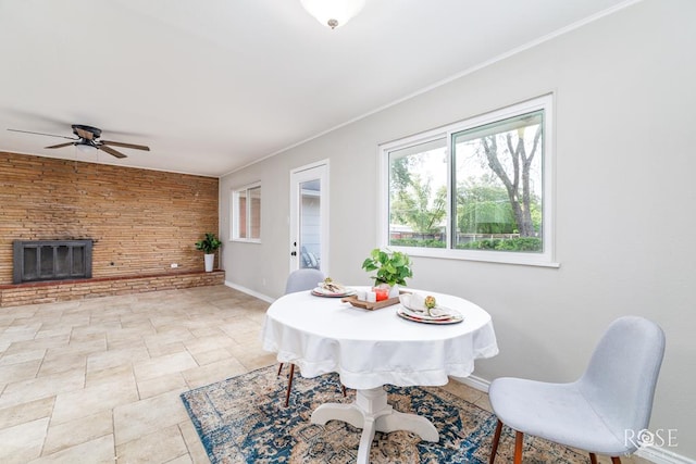 3119 Woodland Cir, San Angelo, TX 76904 - dining area featuring crown molding, baseboards, ceiling fan, and a fireplace with raised hearth