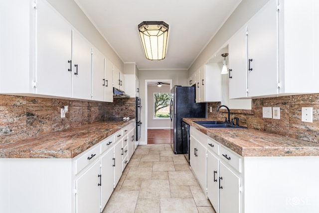 kitchen with white cabinetry, black appliances, sink, and backsplash