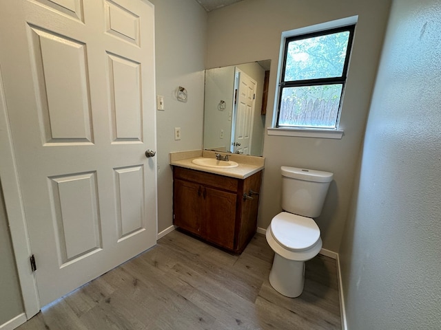 bathroom featuring hardwood / wood-style flooring, vanity, and toilet