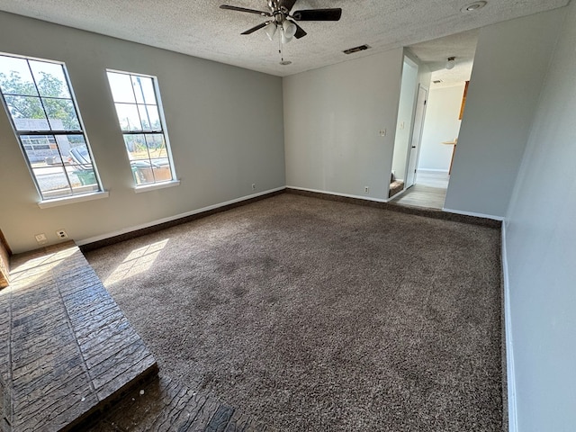 carpeted spare room with ceiling fan and a textured ceiling