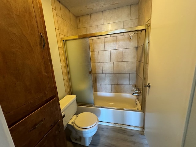 bathroom with wood-type flooring, enclosed tub / shower combo, and toilet