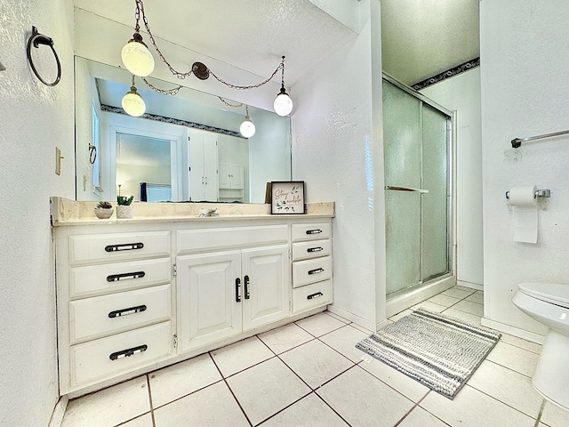 bathroom with walk in shower, vanity, toilet, and tile patterned flooring