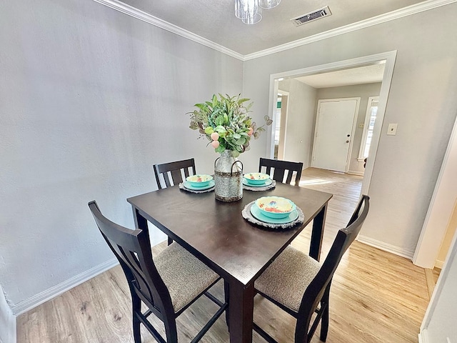 dining space featuring crown molding and light wood-type flooring