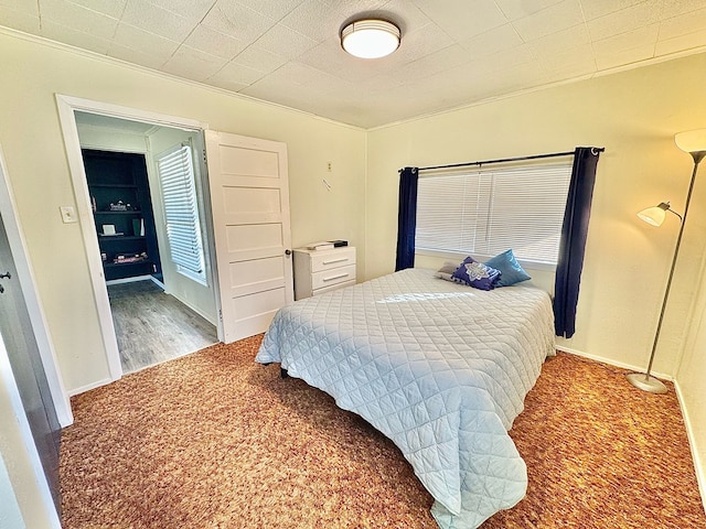 bedroom with ornamental molding and carpet