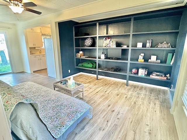 living area with hardwood / wood-style flooring, ceiling fan, and crown molding