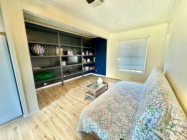 bedroom with hardwood / wood-style floors and crown molding