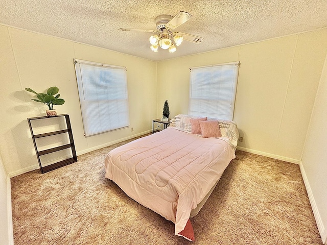 bedroom with light carpet, ceiling fan, multiple windows, and a textured ceiling