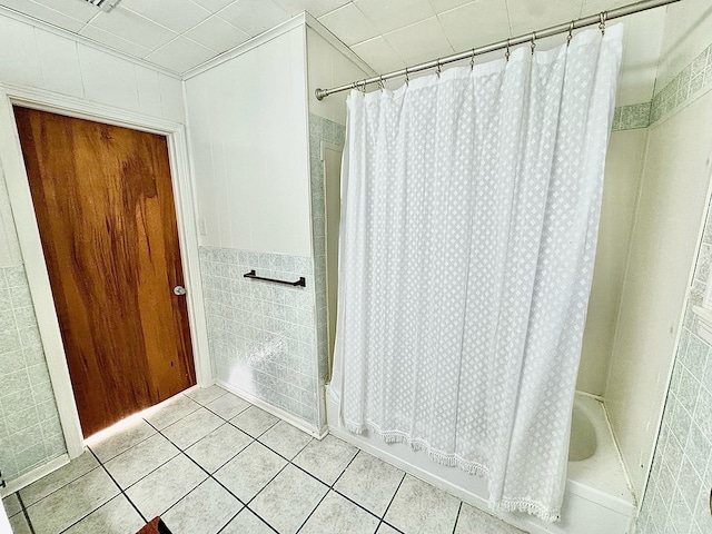 bathroom featuring tile patterned flooring, tile walls, and shower / tub combo with curtain