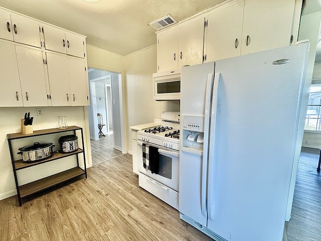 kitchen with white appliances, light hardwood / wood-style floors, and white cabinets