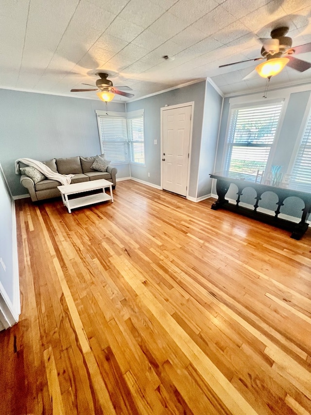 unfurnished living room featuring crown molding, ceiling fan, and light wood-type flooring